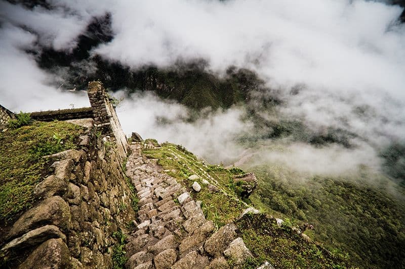 Discesa vertiginosa della montagna Huayna Picchu un giorno piovoso Discesa vertiginosa della montagna Huayna Picchu un giorno piovoso